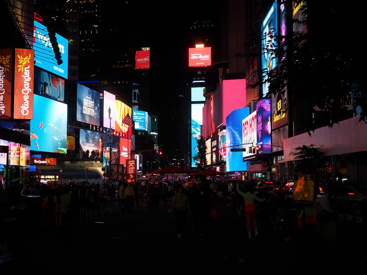 Crowded urban city street with digital screens