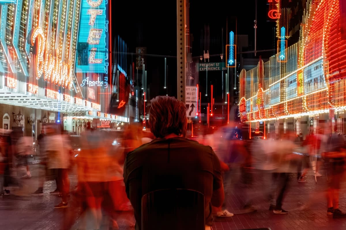 a lonely person in a crowded neon city