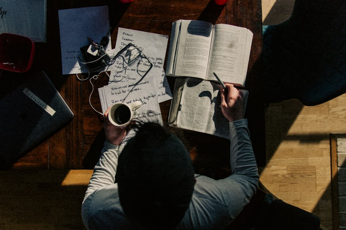 person intensely studying with complex diagrams and handwritten notes