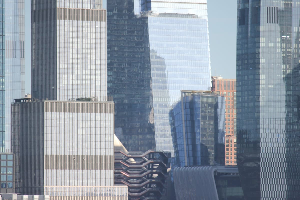Modern glass skyscraper reflecting a city skyline