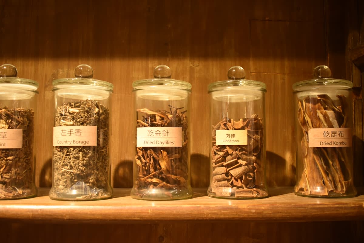 Dried seeds in glass jars on a wooden shelf