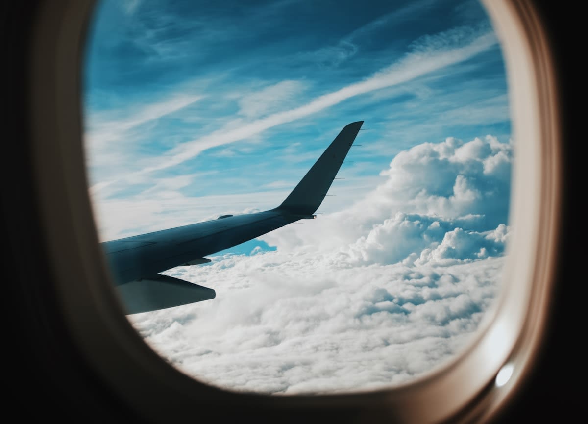 Airplane wing over clouds