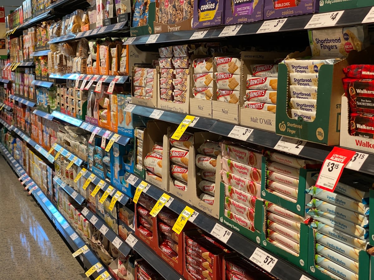 Modern supermarket aisles with a focus on fresh produce vs processed snacks
