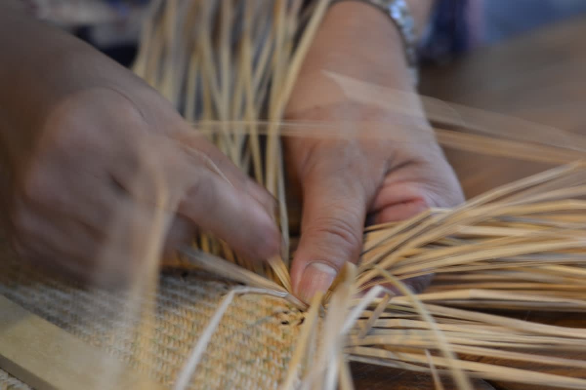 Hands working on a traditional loom