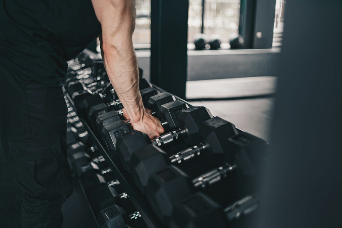 Close up of a person lifting a dumbbell in a gym