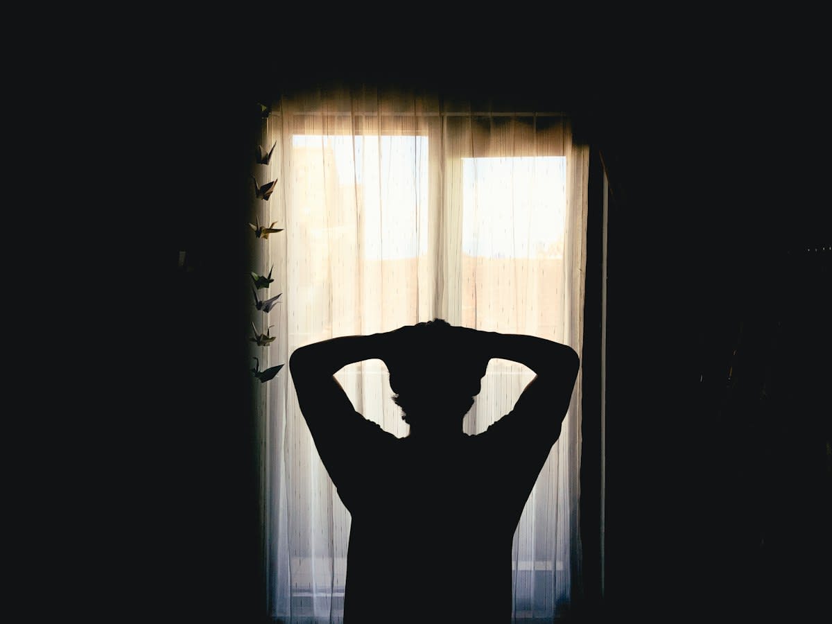 Person thinking deeply in a dark room