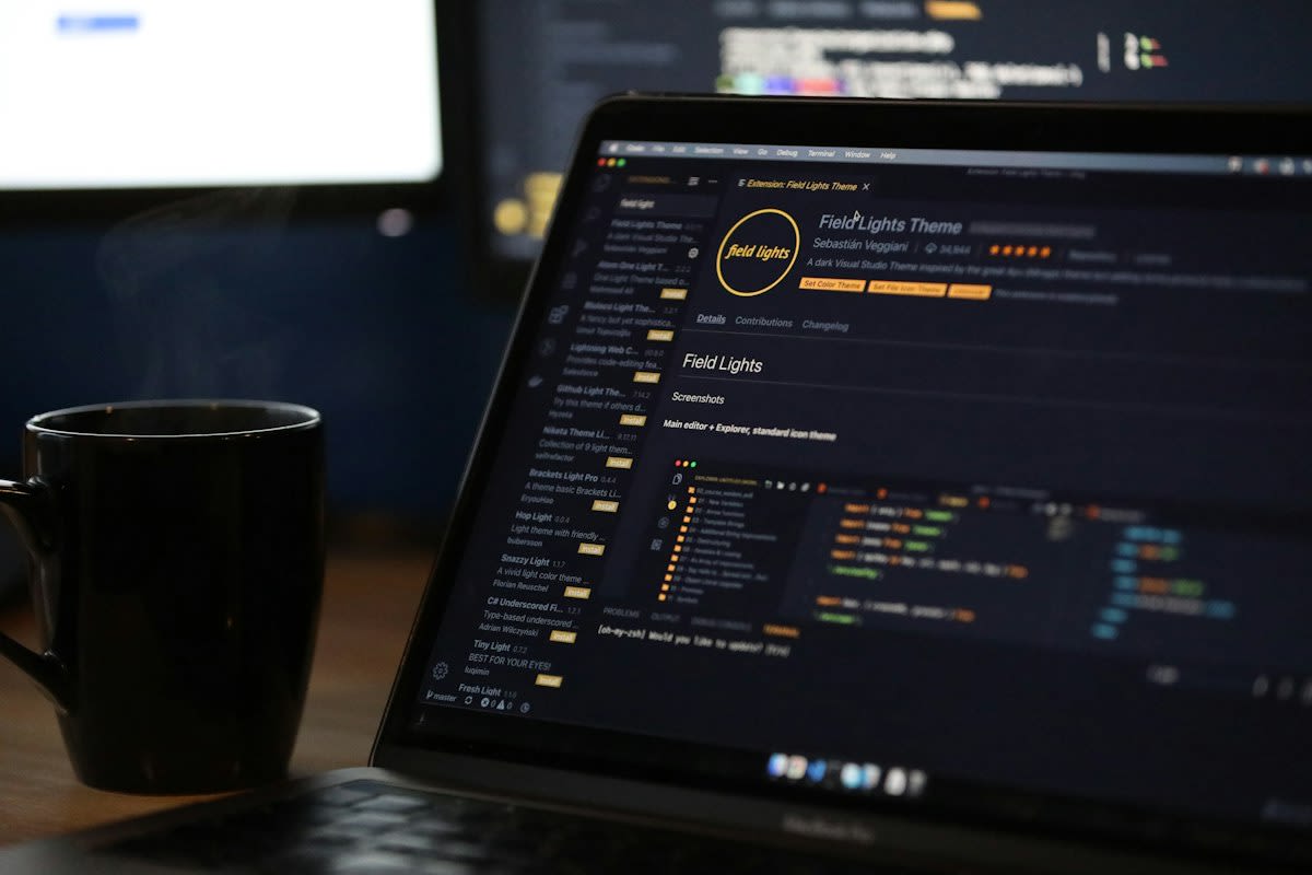 Close up of a computer screen showing a complex spreadsheet and a cup of cold coffee