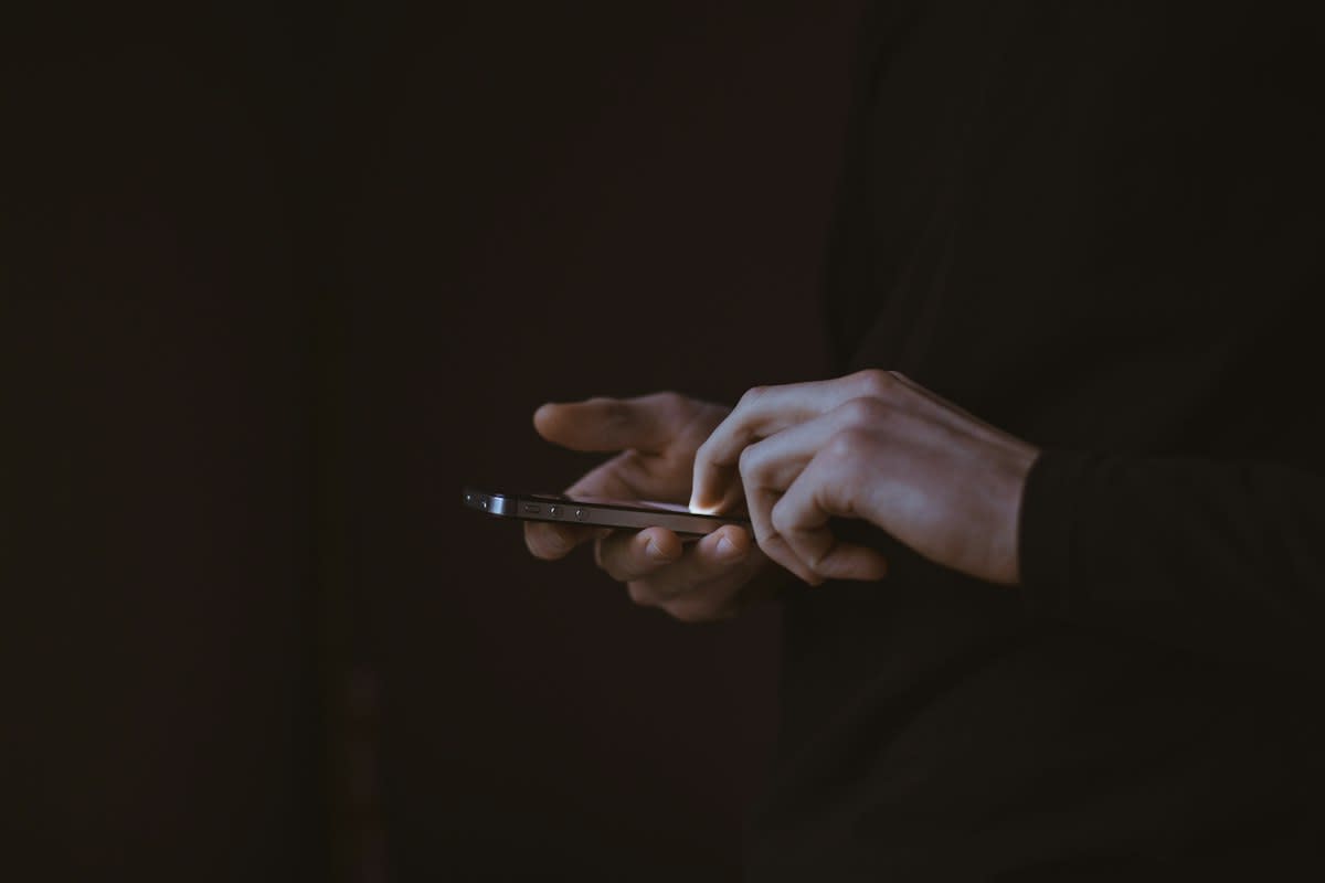 Person holding a smartphone vertically showing a dramatic scene