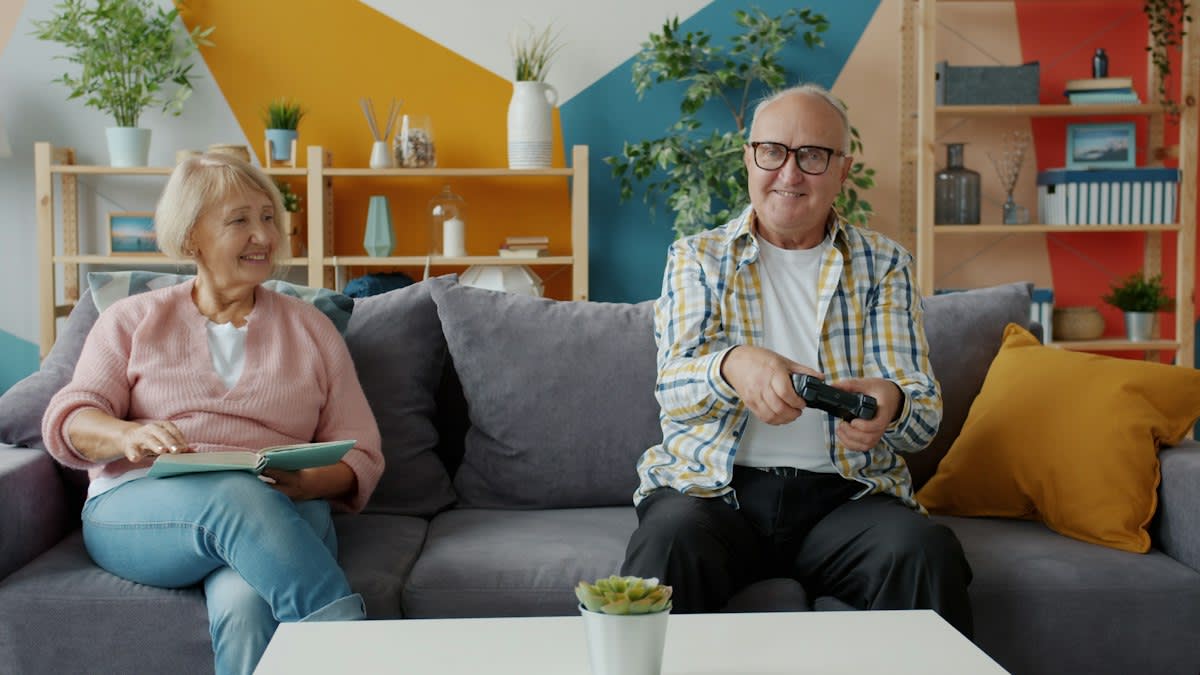 Professional caregiver and elderly person talking in a modern living room
