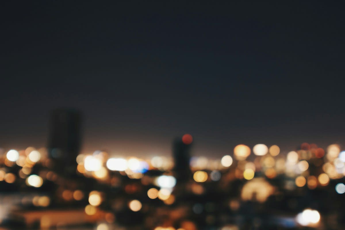 blurred city lights and a lonely figure