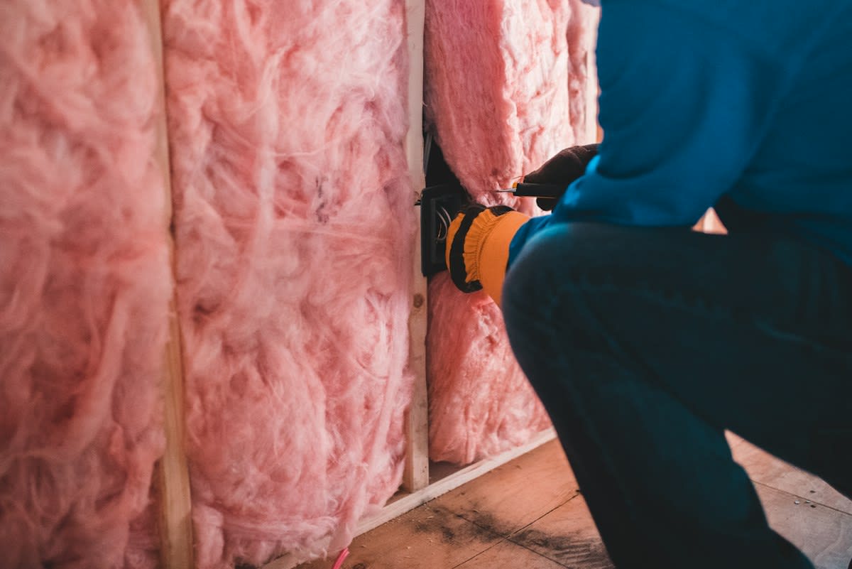 construction worker inspecting wall insulation