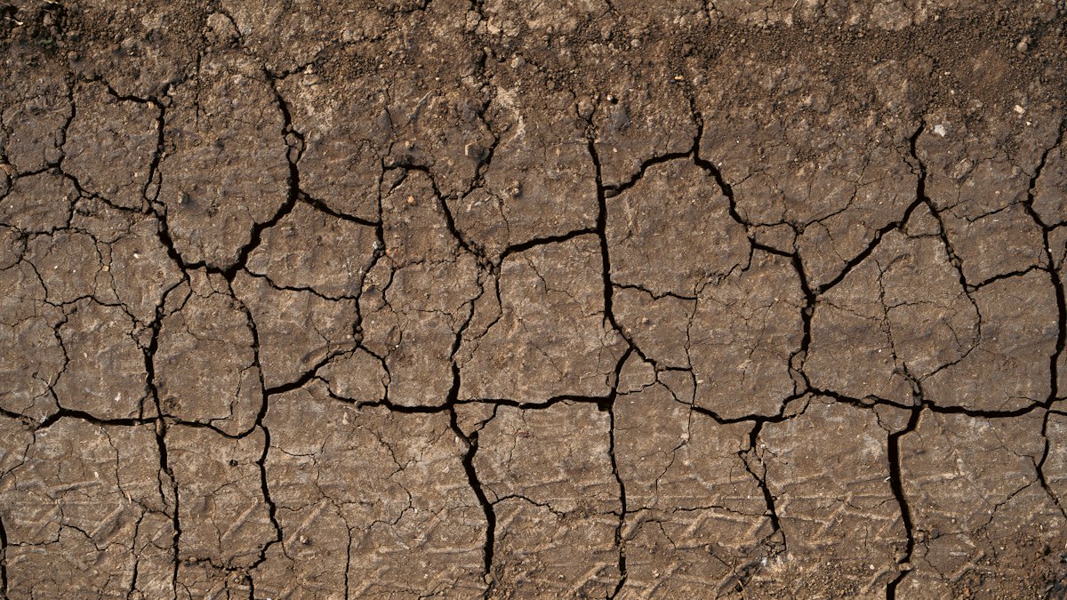 close up of cracked dry soil near industrial construction