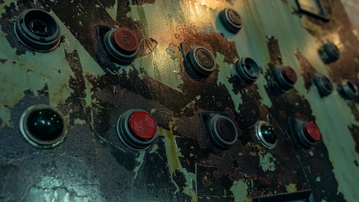 Close up of a worn industrial control panel with manual overrides