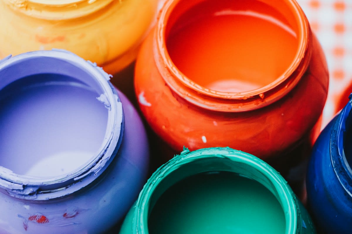 Close up of paint rollers and colorful paint cans