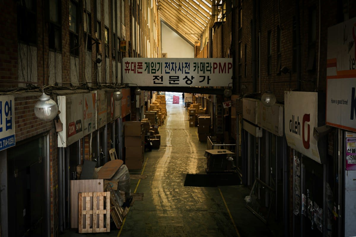 A dimly lit, concrete corridor in a Seoul basement clinic