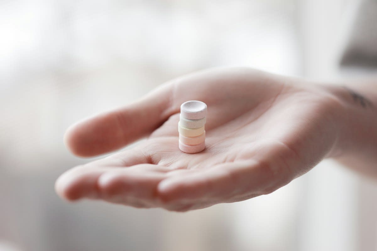 Close up of a weathered hand holding a high-tech medical vial