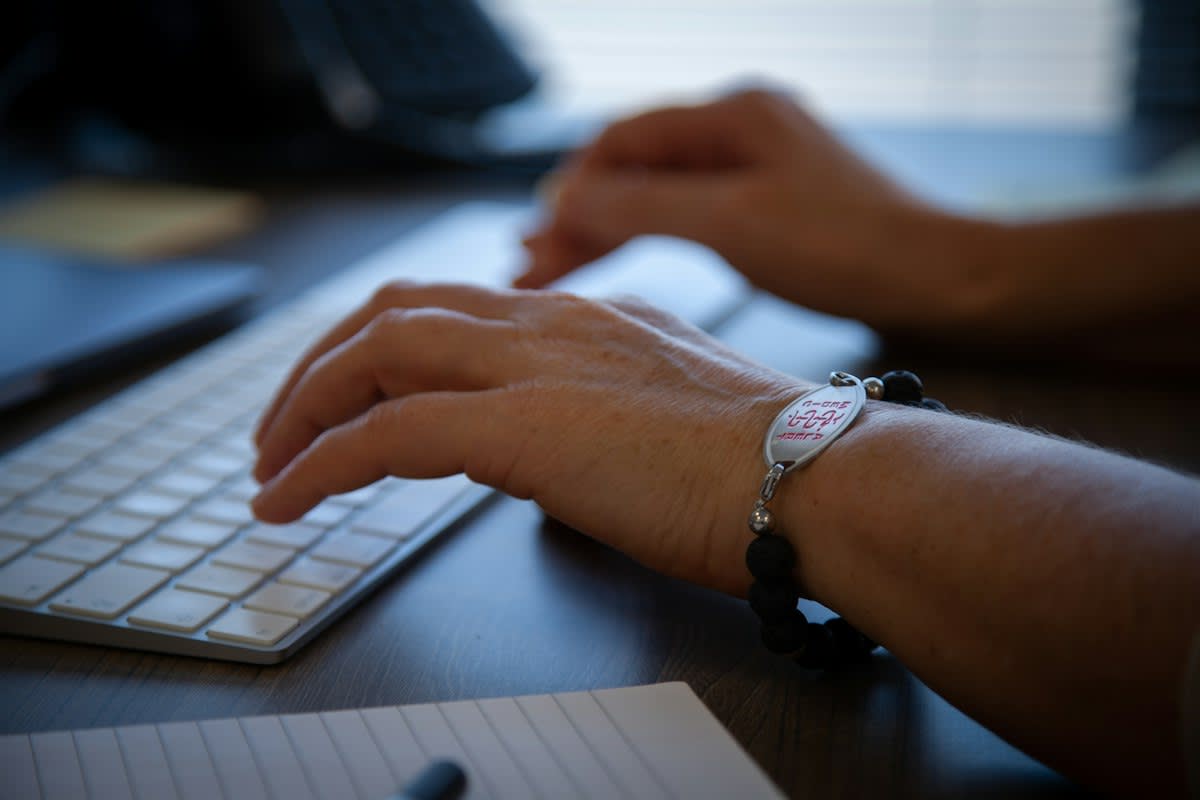 Close up of hands on a keyboard in a dimly lit office
