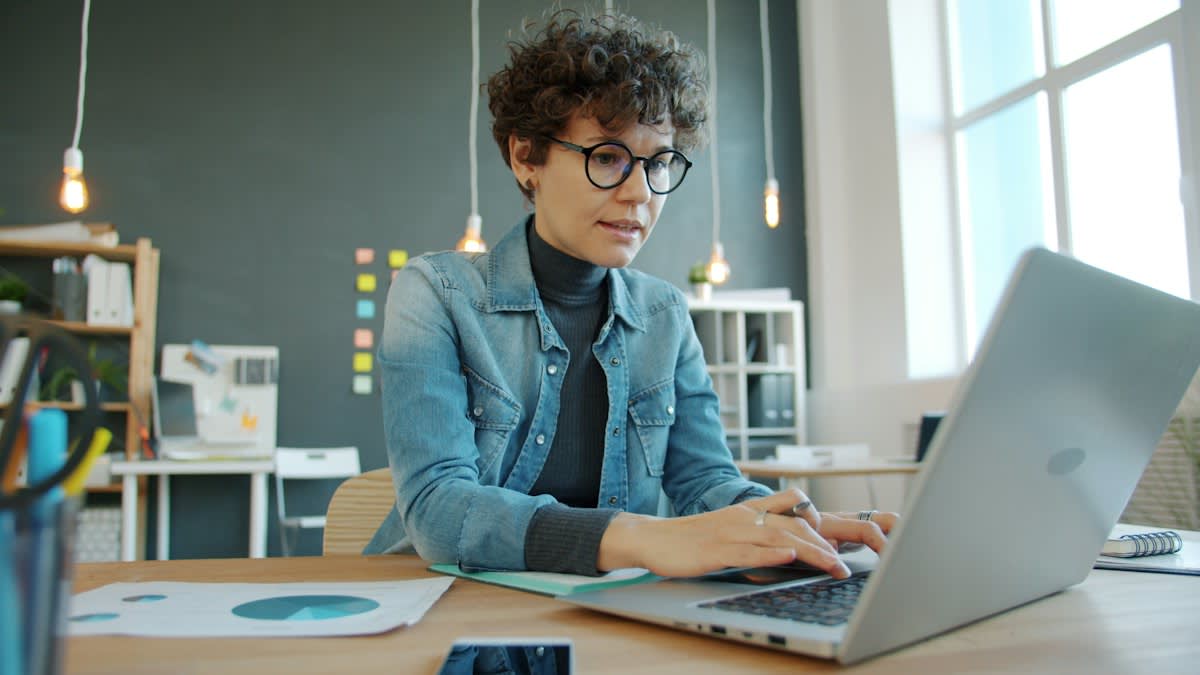 Person typing on a laptop in a modern office