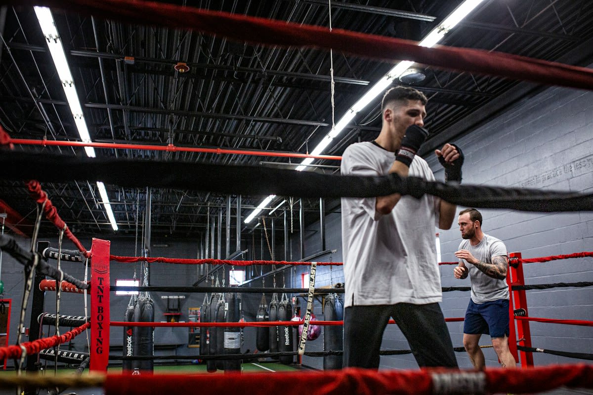 Two fighters sparring in a gritty gym