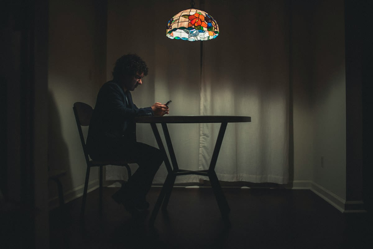 Person staring at a phone in a dark room