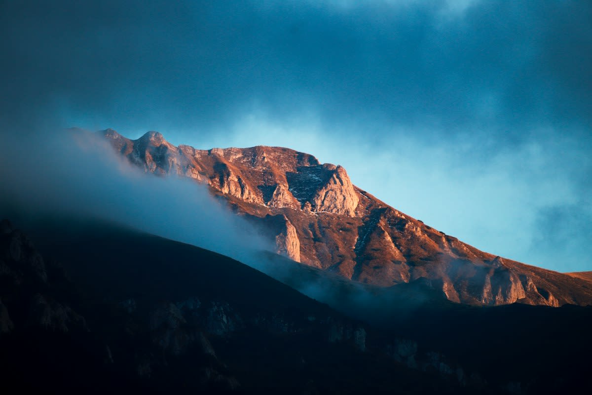 Sun rays hitting a mountain peak