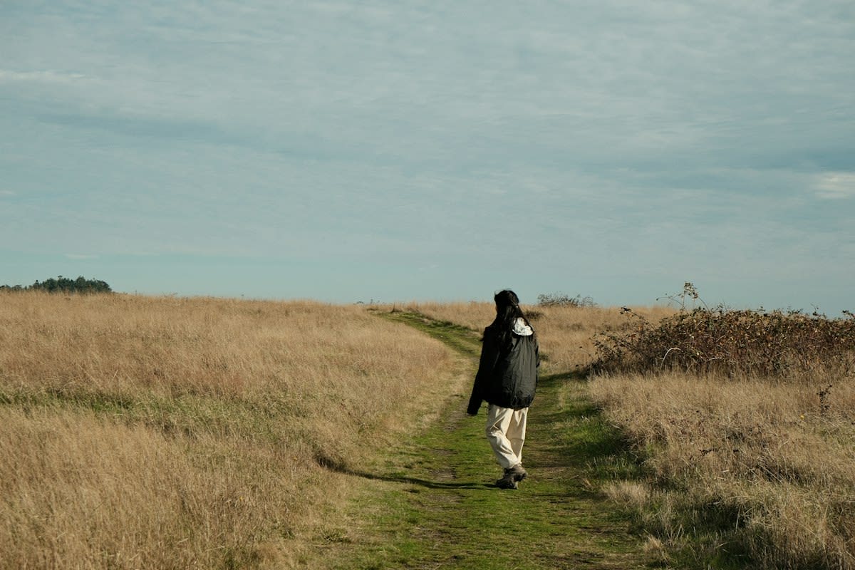 Person walking in a natural setting to reduce stress