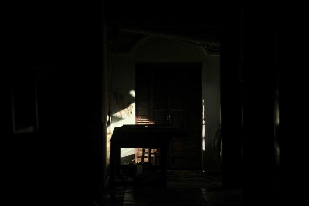 Old oil lamp on a wooden table in a dark room