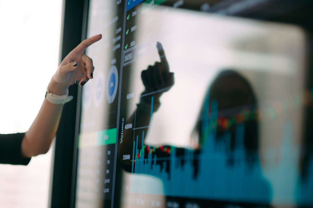 Data visualization on a screen with a human hand pointing