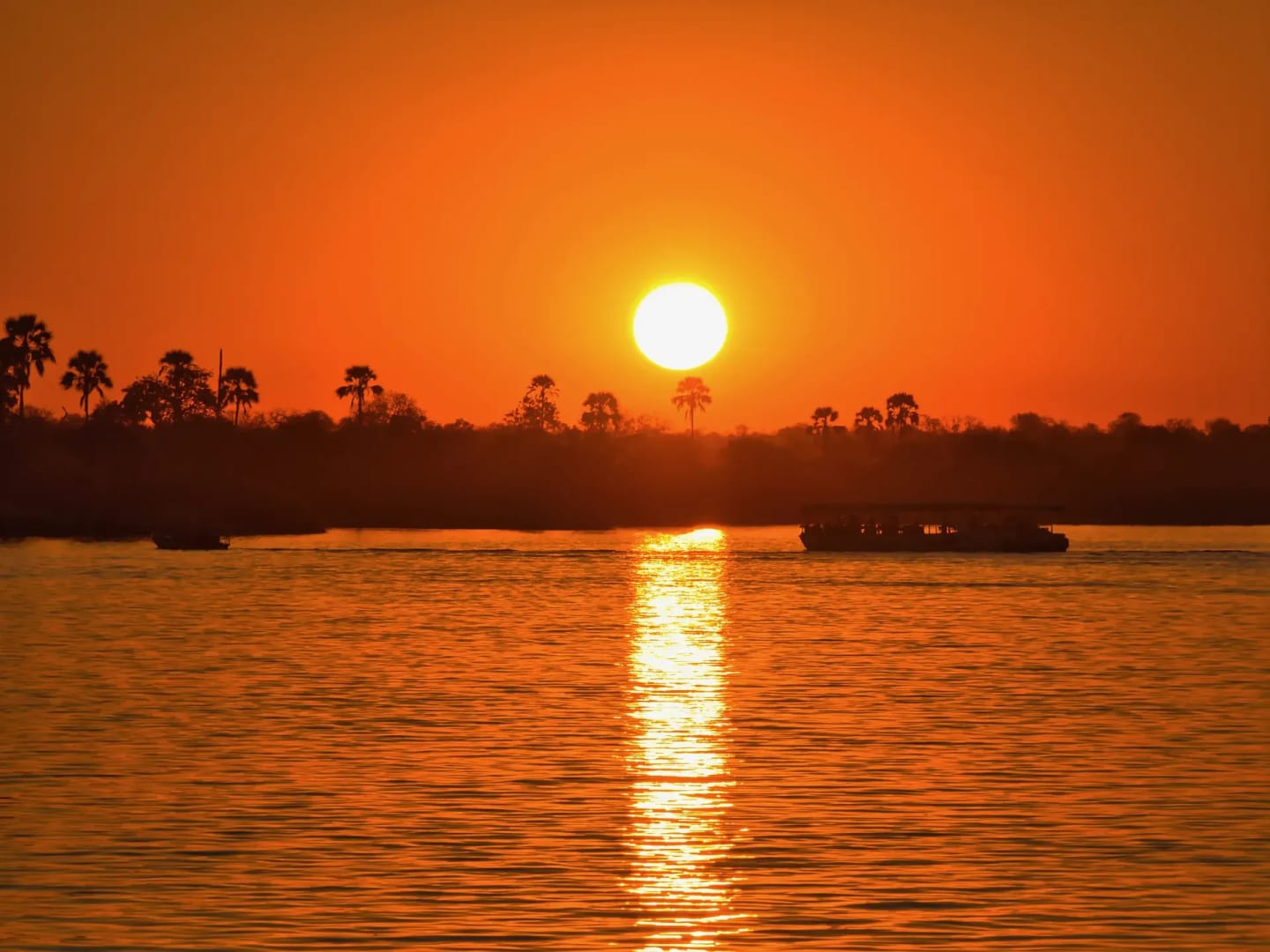 Sun setting over the river with a golden reflection on the water during a sunset cruise