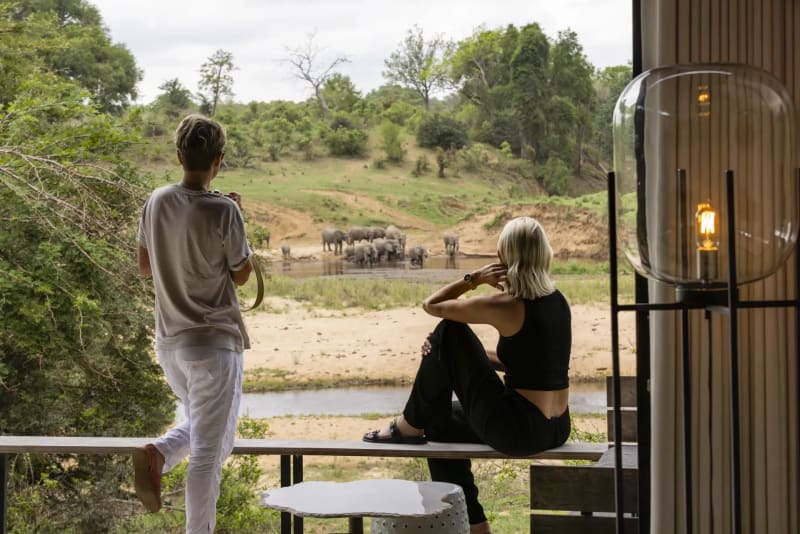 Guest sitting on a bench in the savanna, enjoying panoramic safari views under the open sky