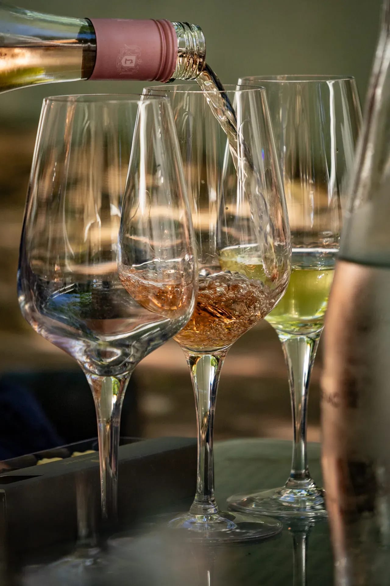 Glasses of white wine and gourmet appetizers on a wooden table at an elegant dining setting
