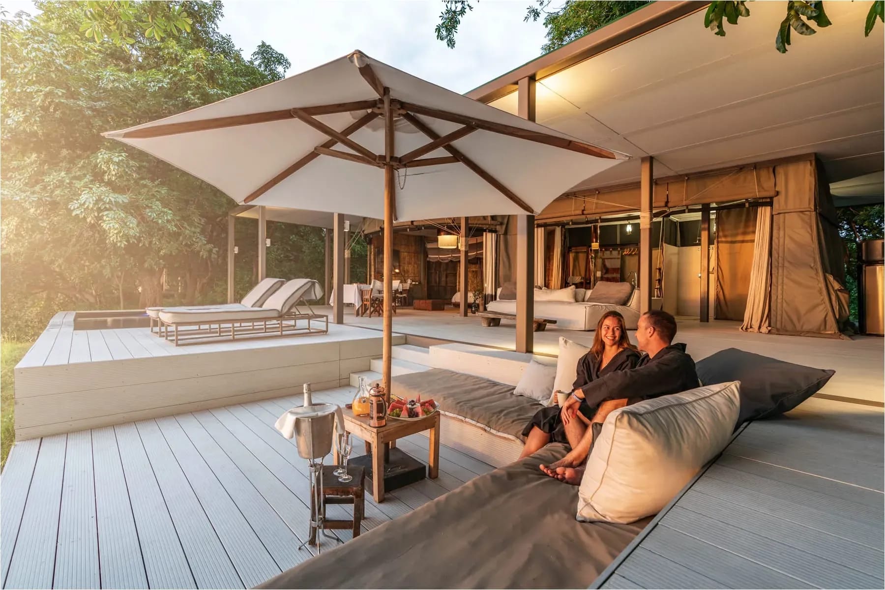 Luxury safari lodge deck at Time + Tide Chinzombo with canvas roofs, wooden deck, and comfortable seating overlooking the wilderness