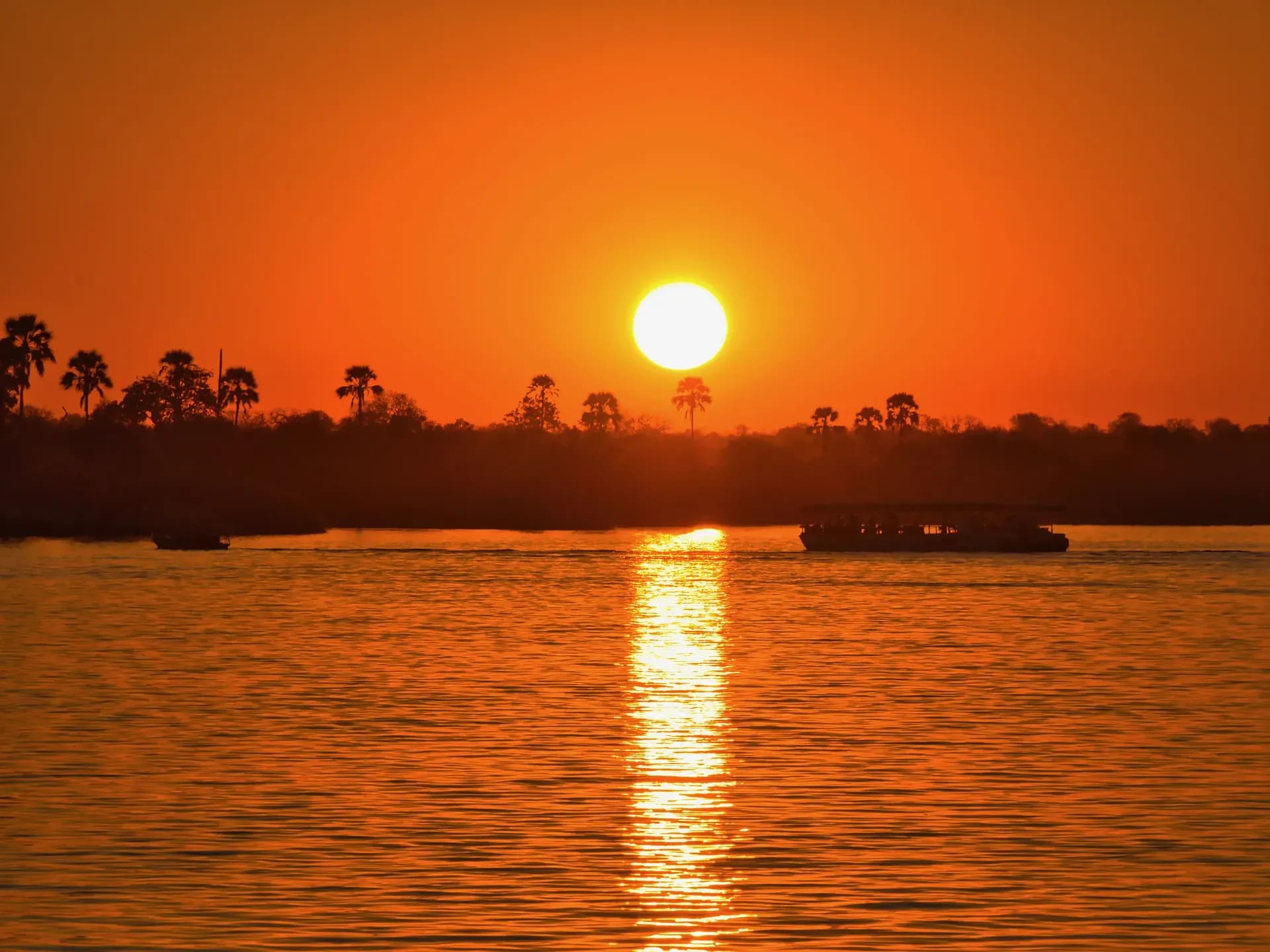Sun setting over the river with a golden reflection on the water during a sunset cruise