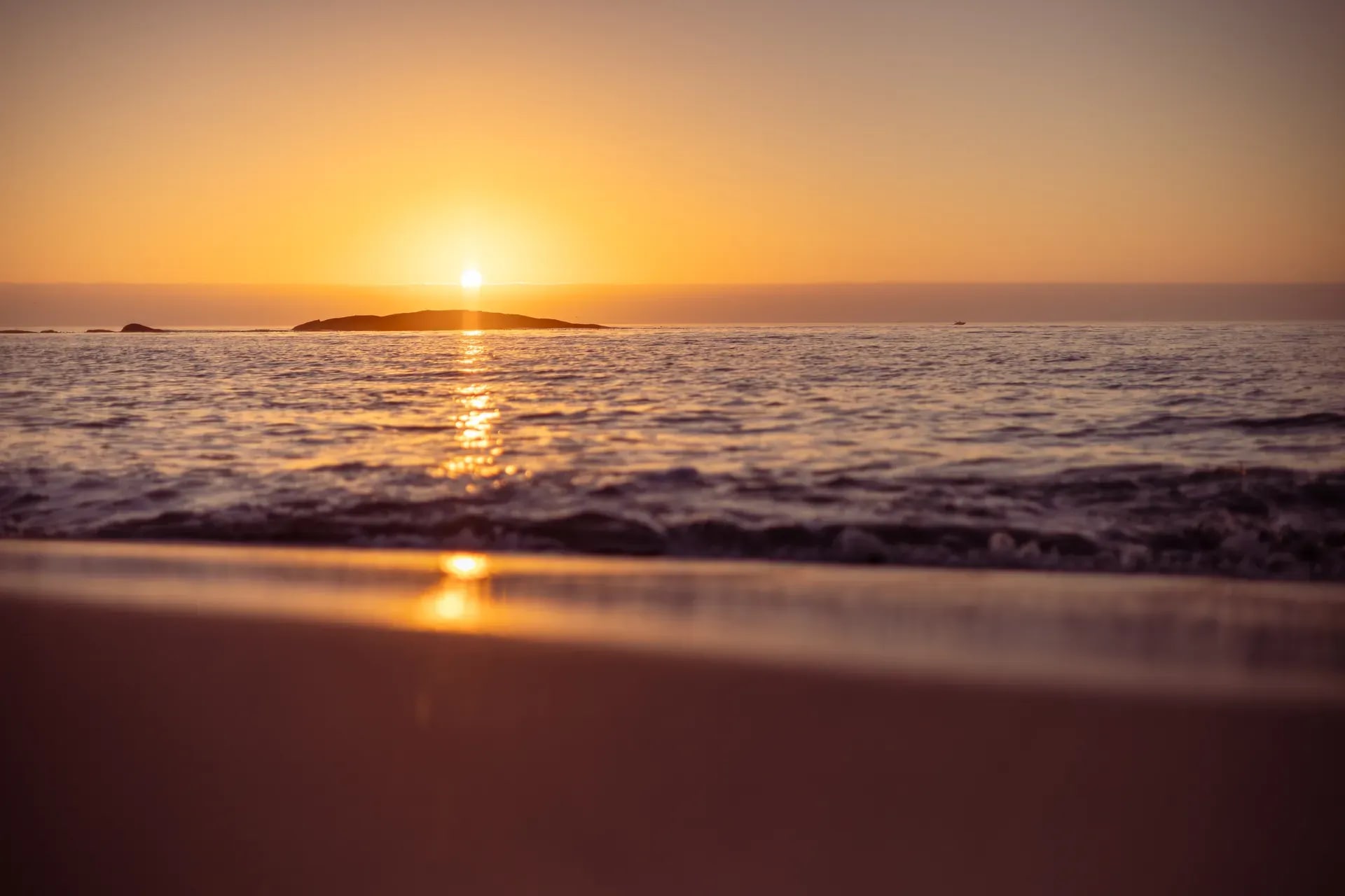 Sunset over the ocean at Milnerton with a golden sky reflecting on gentle waves