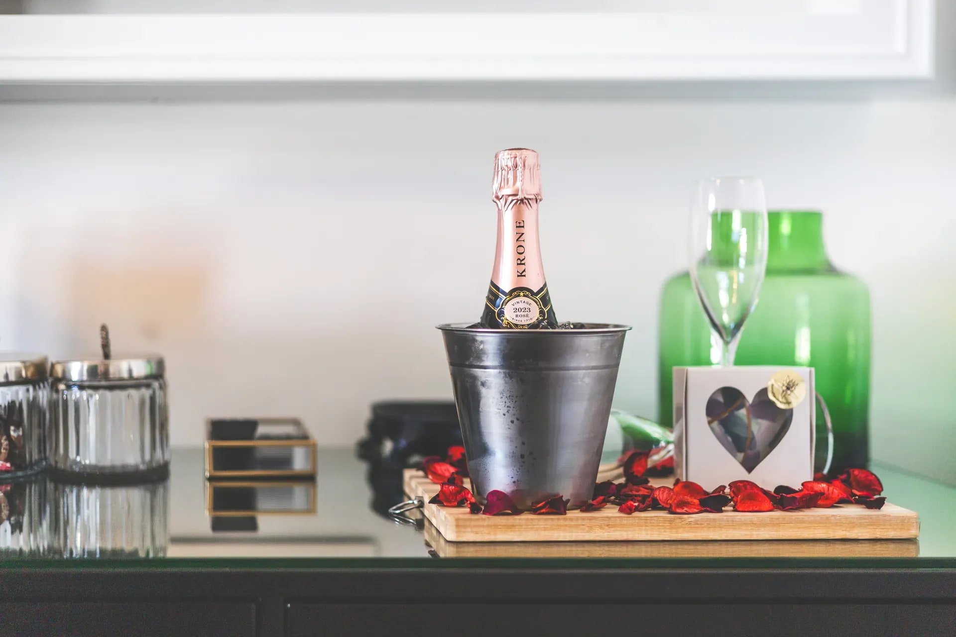 Romantic turndown service featuring champagne in an ice bucket and chocolates arranged on a tray