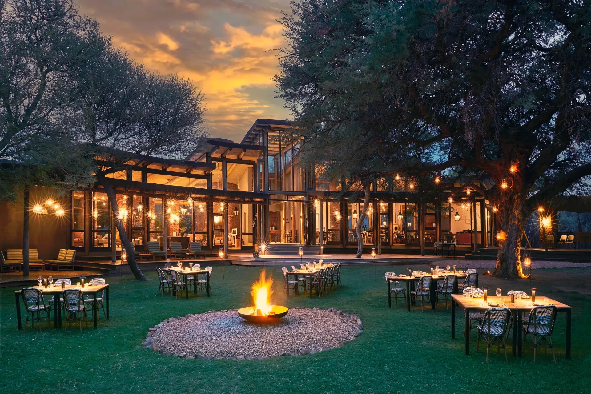 Marataba Safari Lodge – Outside dining with fire pit and set tables under the stars.