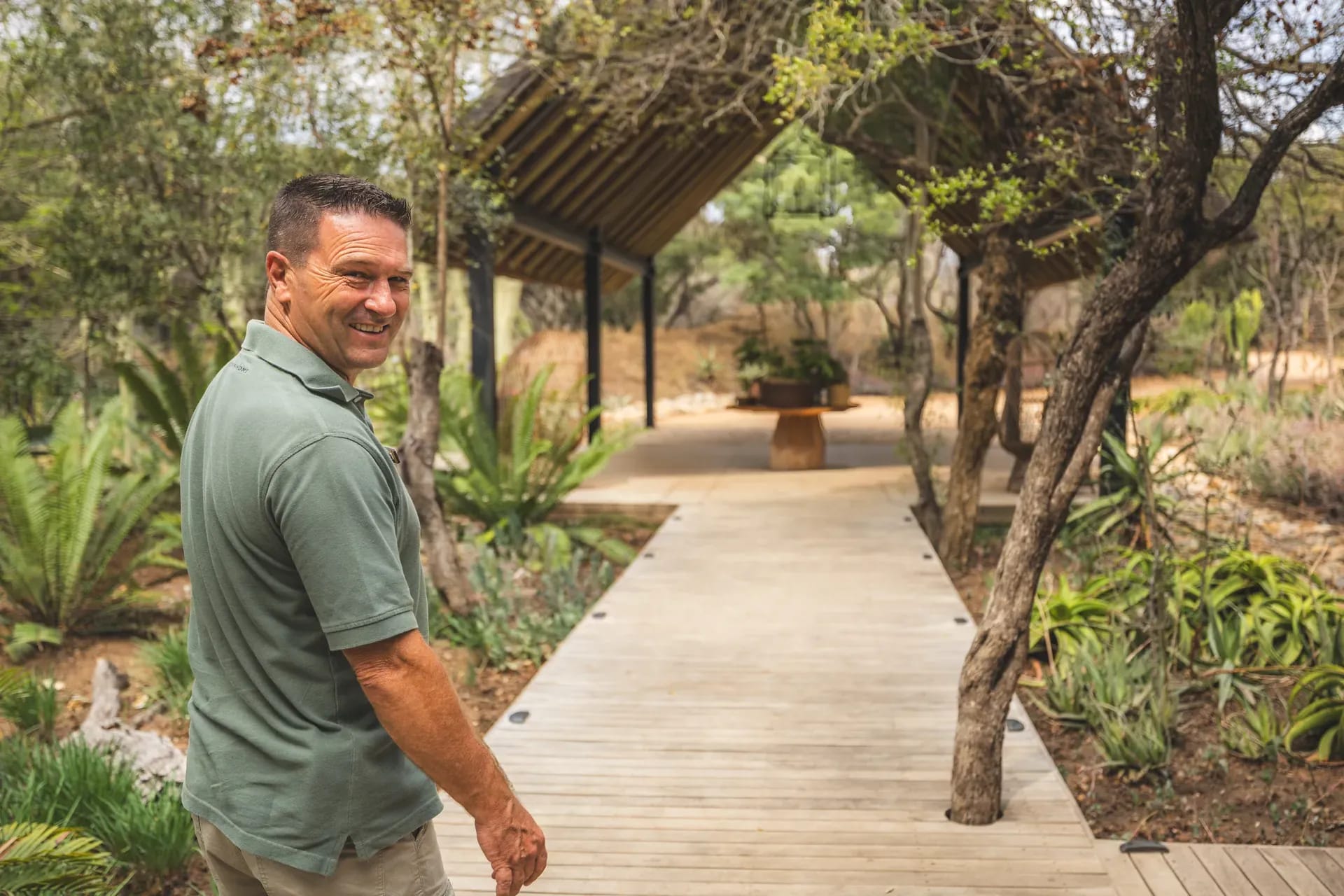Guest walking into Monwana Lodge with the garden visible in the background.