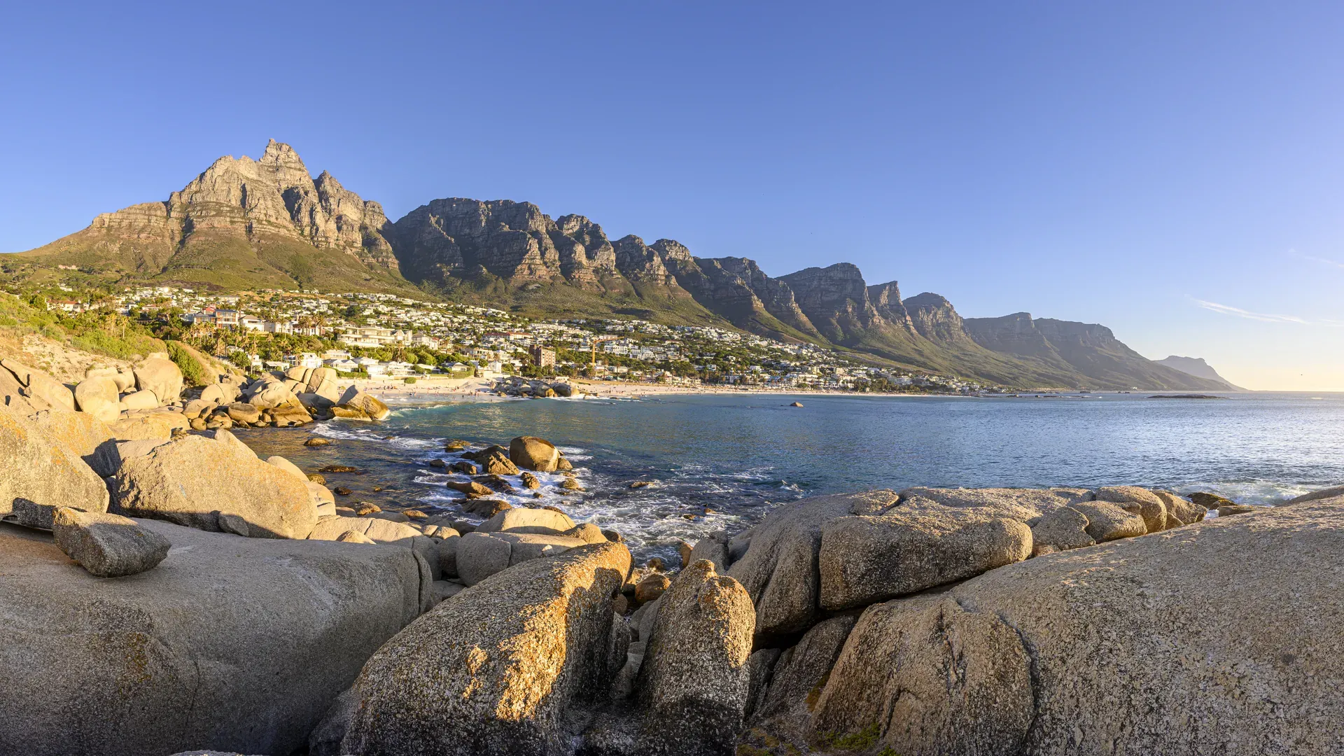 Rugged landscape with rocky hills and sparse trees under a clear blue sky