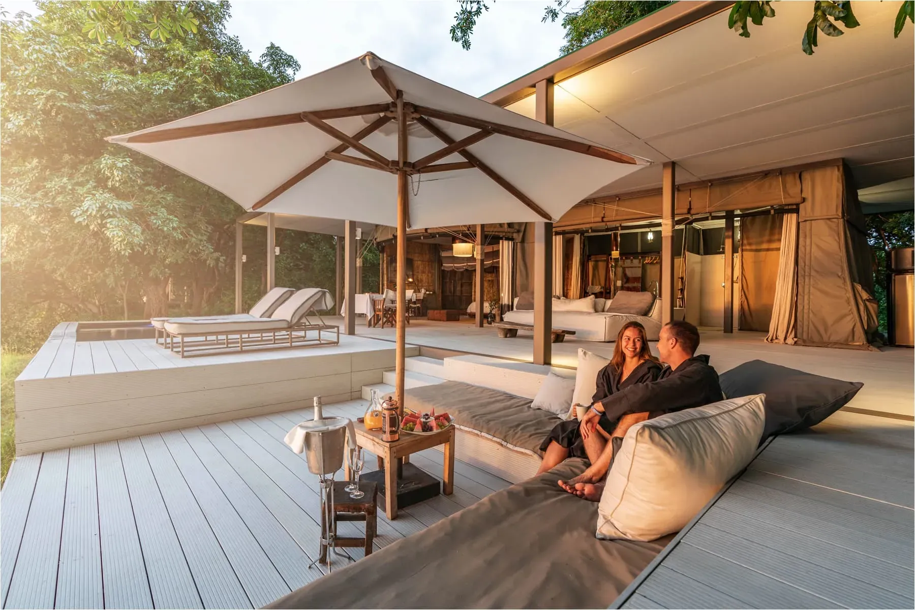Luxury safari lodge deck at Time + Tide Chinzombo with canvas roofs, wooden deck, and comfortable seating overlooking the wilderness