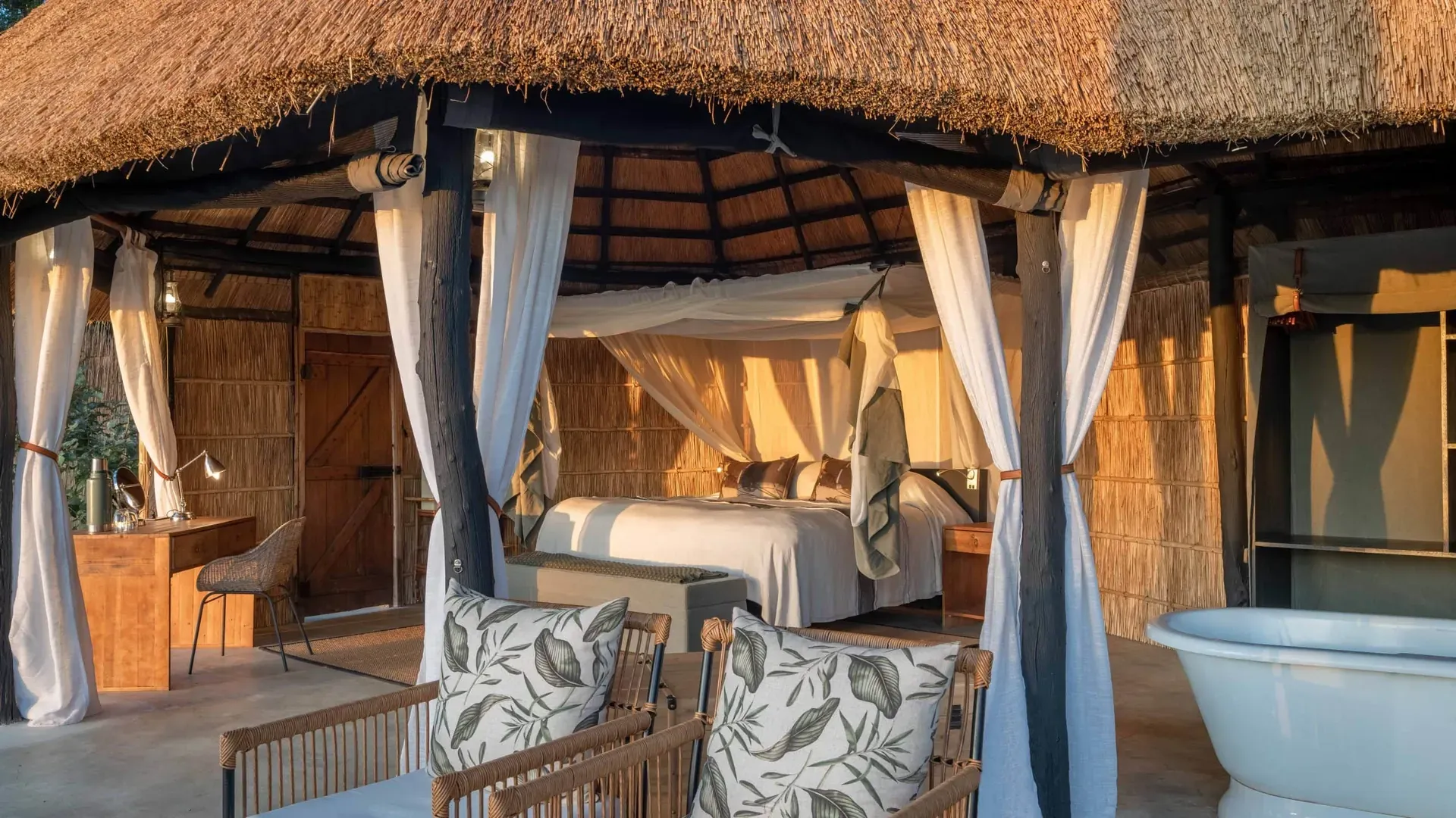Luxurious safari tent at Time + Tide Mchenja Bush Camp featuring a canopy bed with mosquito net and comfortable seating