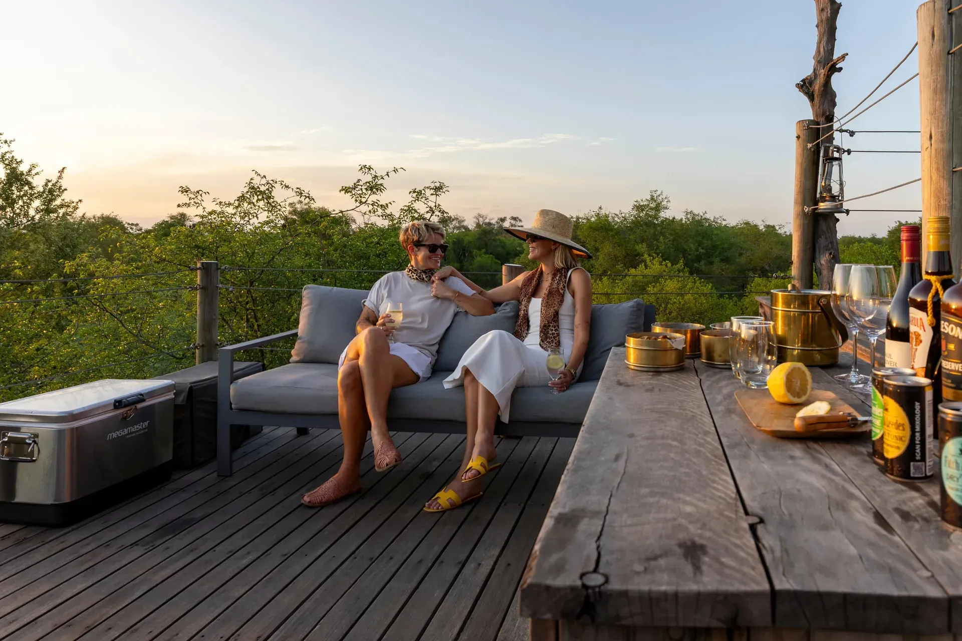 Group of friends celebrating on a wooden deck by a pool, raising drinks during a milestone event