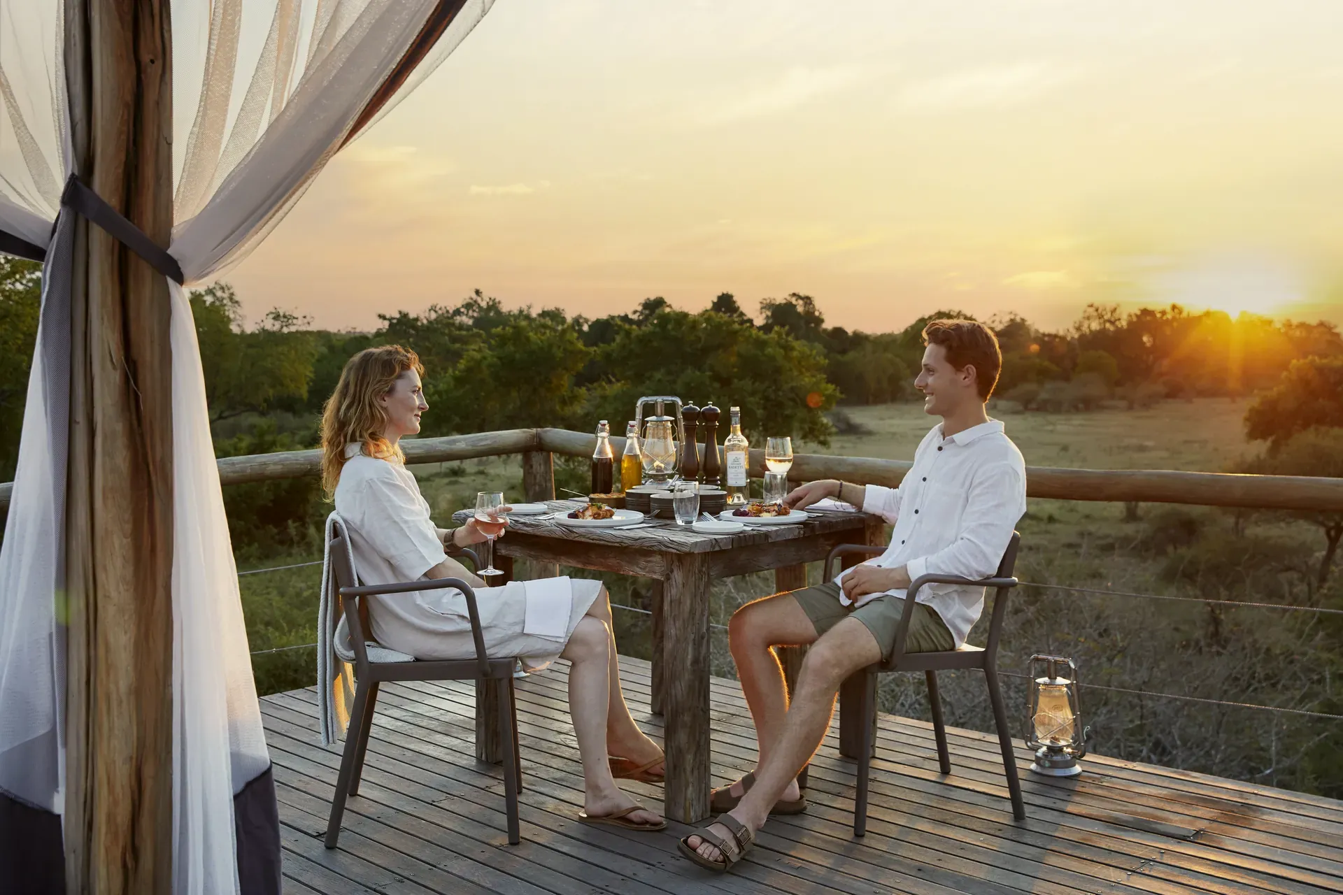 Guests enjoying a meal on the deck of Chalkley Treehouse with canopy and surrounding nature