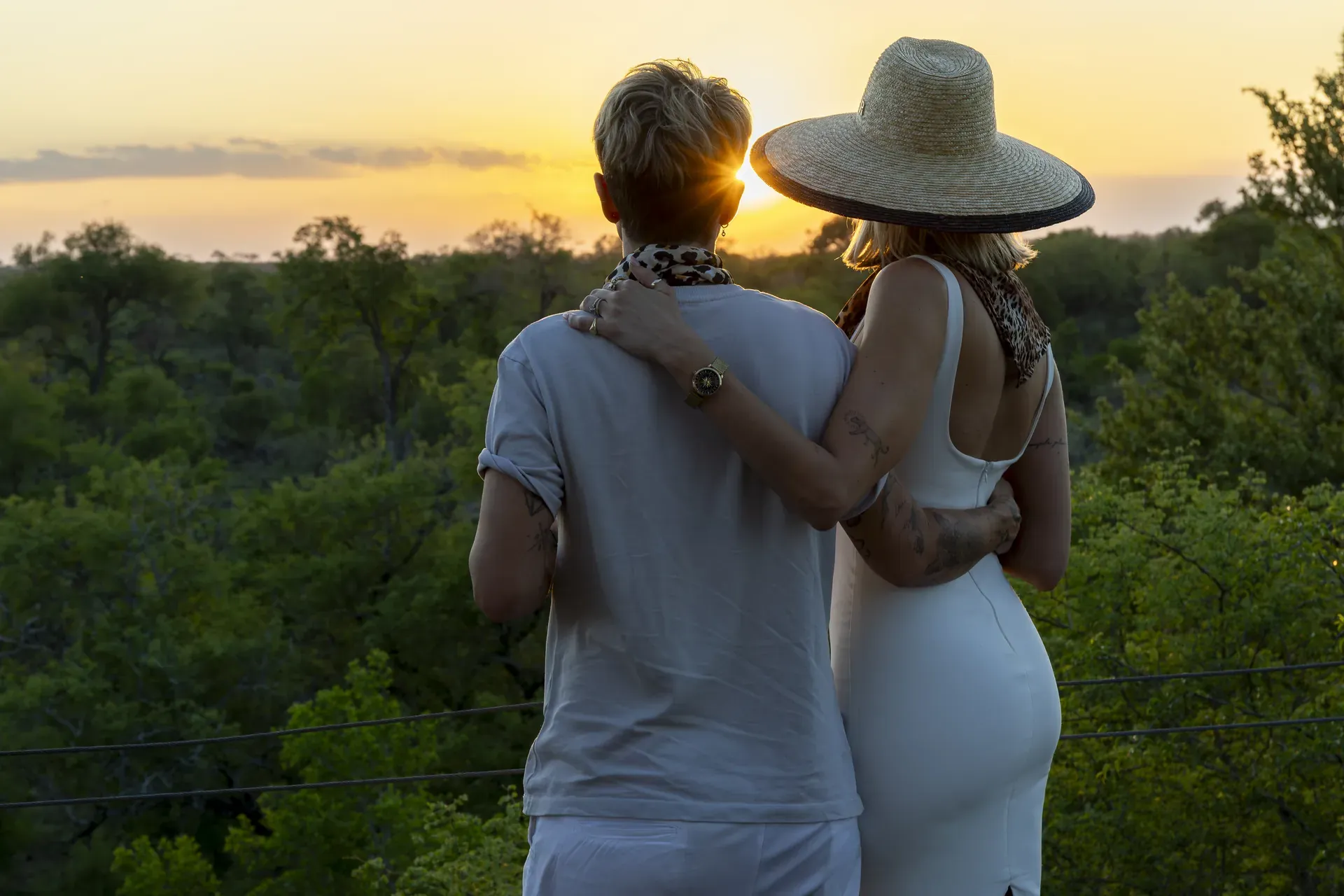 Couple embracing while watching the sunset from Lion Sands Kingston Treehouse