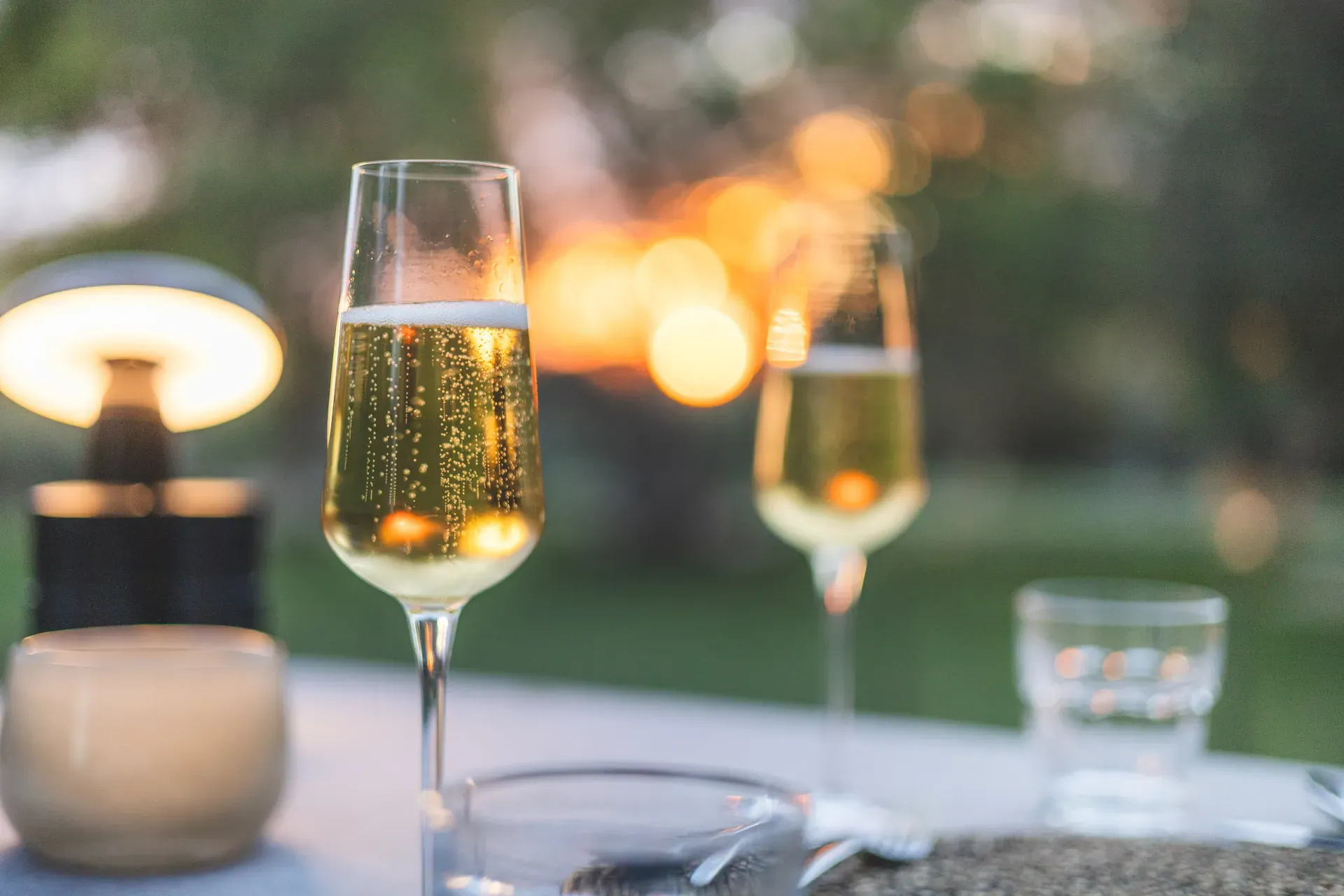 Champagne glasses glowing during a romantic dinner setting at MTSL, with blurred background lights