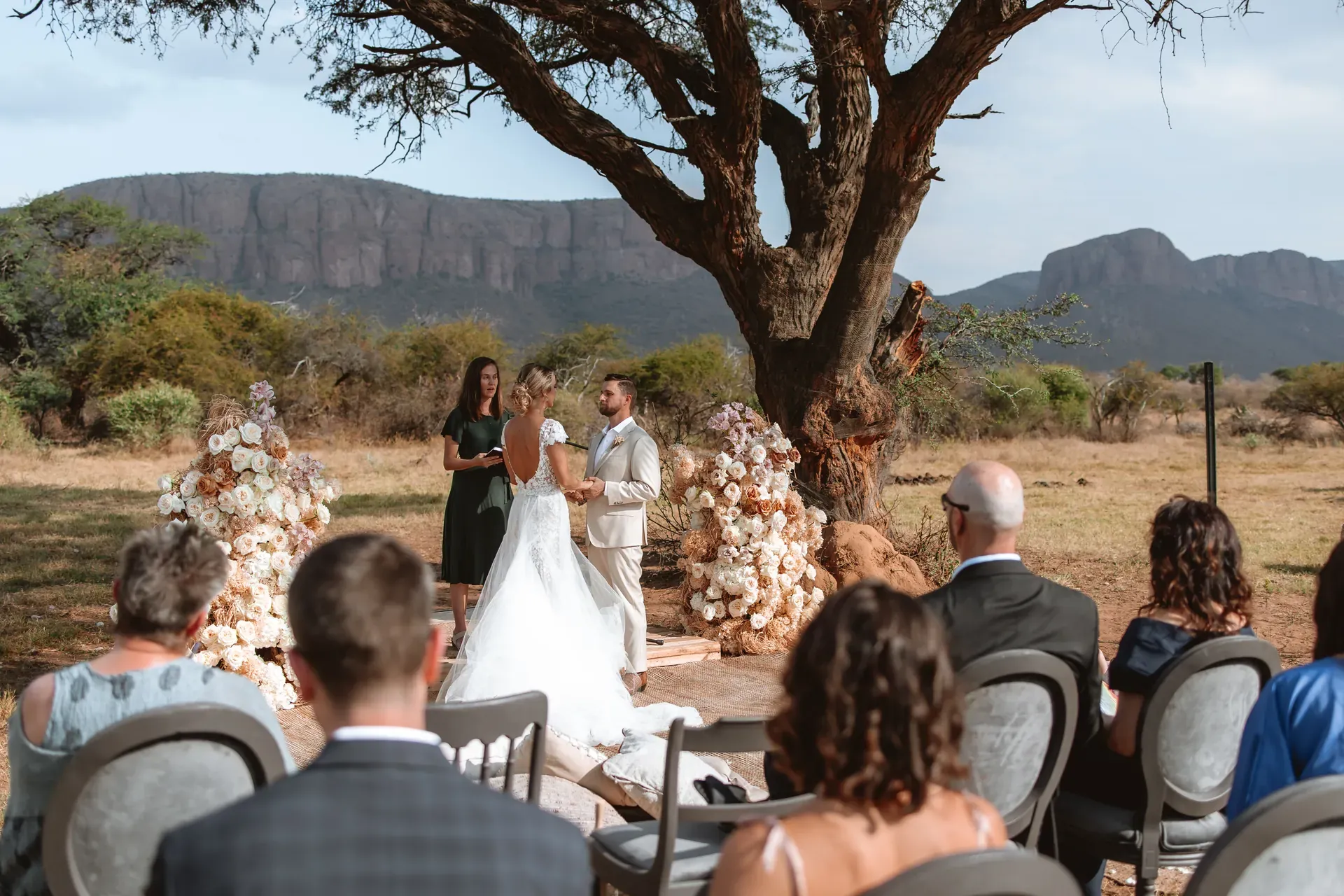 Wedding ceremony held under a tree at Marataba with scenic bush and mountain views in the background.