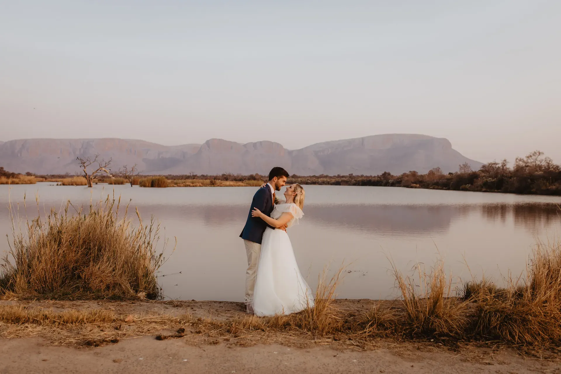 Just-married couple at Marataba with views of mountains and a dam.