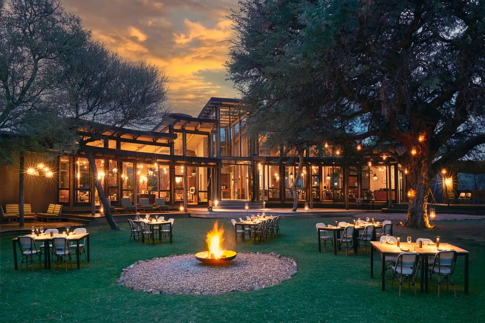 Marataba Safari Lodge – Outside dining with fire pit and set tables under the stars.
