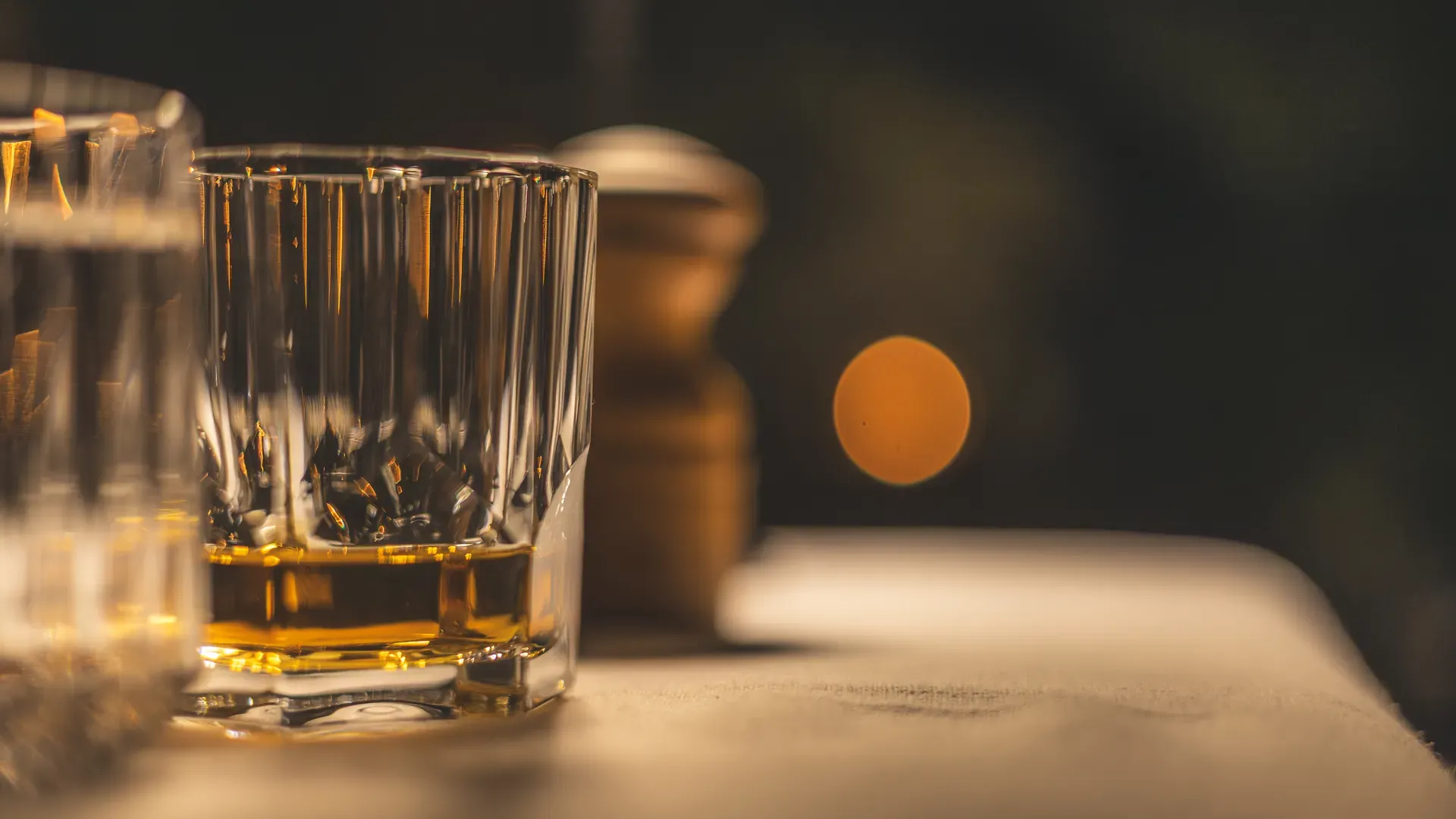 Close-up of a tumbler with a drink at Monwana Lodge on a dark night.