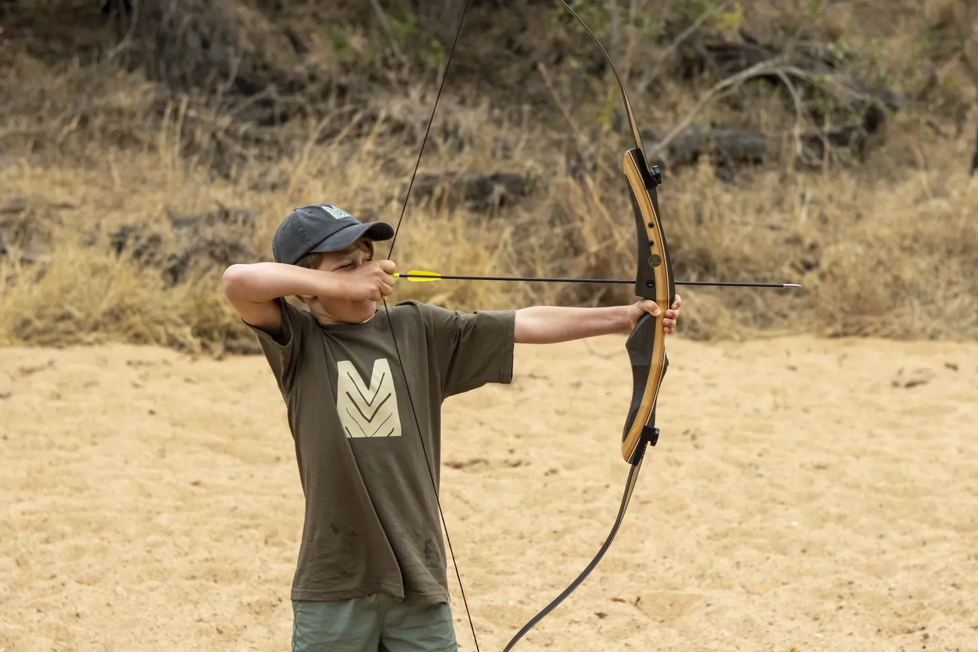Boy practicing archery during the Mosaba Rangers kids program at Monwana.