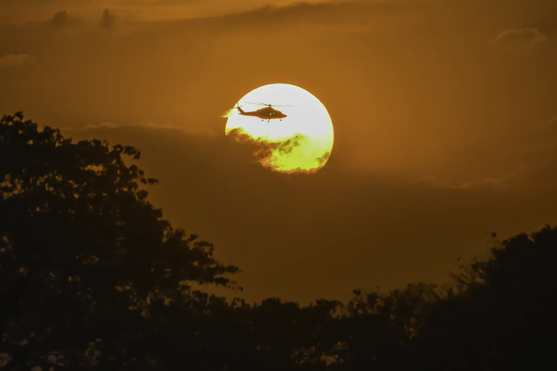 Helicopter flying over the African bush at Monwana Lodge during sunset.